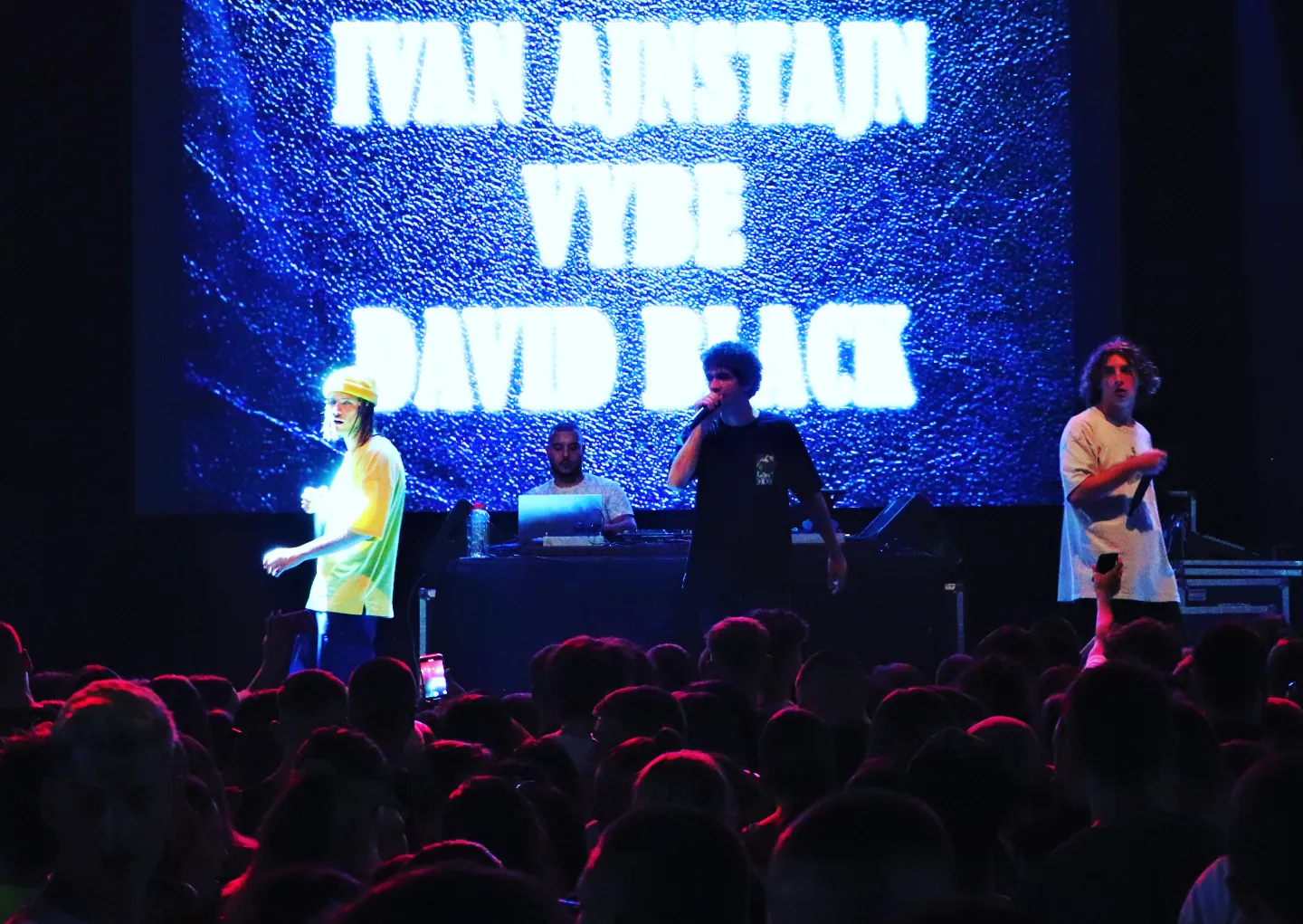 David Black performing onstage with a DJ and guest performers in front of a crowd